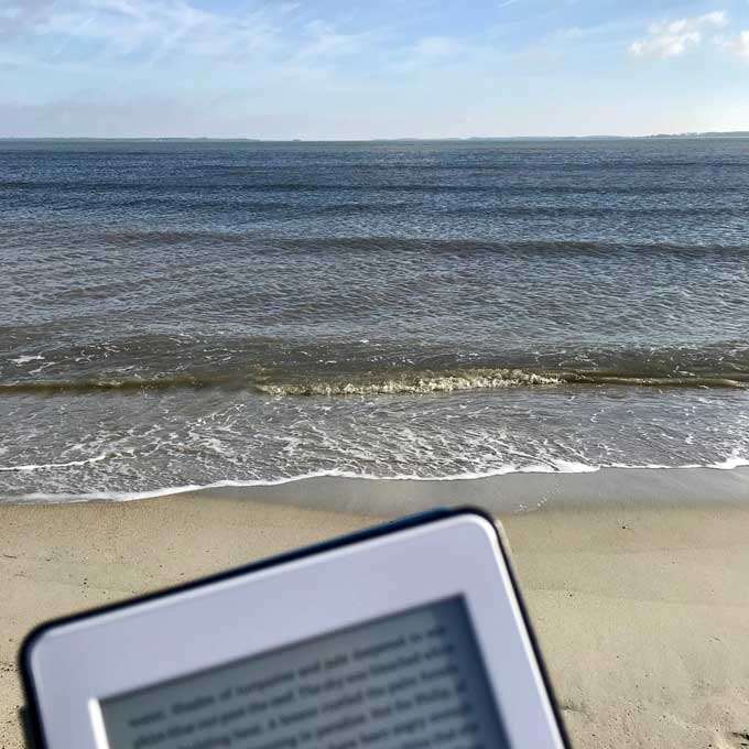 Beach with Kindle Paperwhite in the foreground.