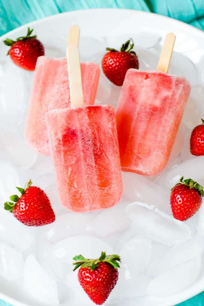 Rose popsicles with strawberries on ice