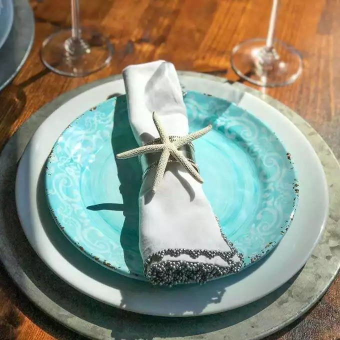 Coastal table top - starfish napkin ring, aqua and white plates, rustic metal charger