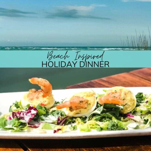 Beach inspired holiday dinner with plate of shrimp appetizers on table next to water.