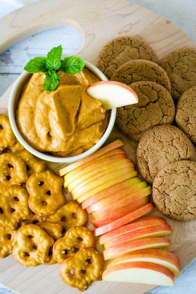 Pumpkin pie cheesecake dip with apple slices, ginger snaps, pretzels