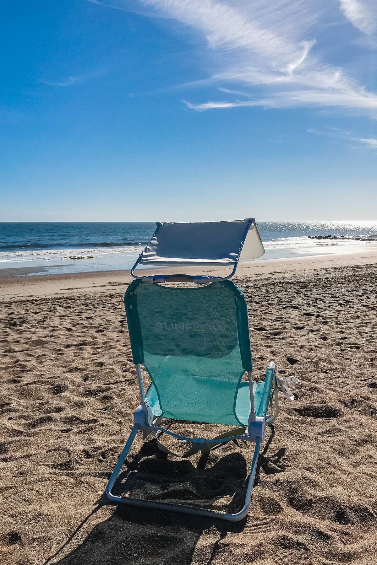Blue beach chair with ocean in the background.