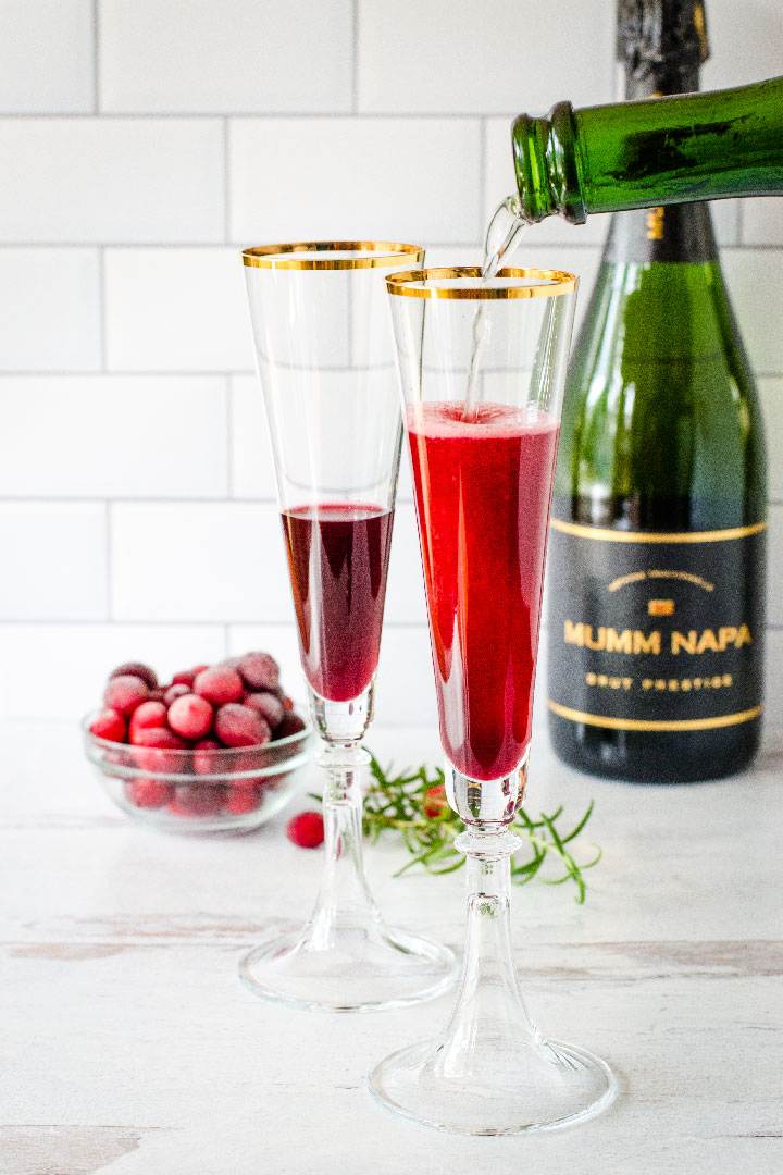 Champagne pouring into glass with pomegranate juice