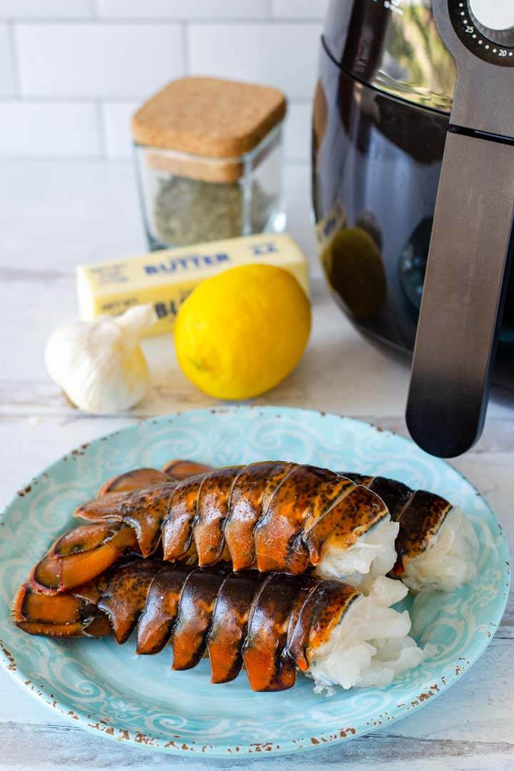 Raw lobster tails, whole garlic, lemon, stick of butter, dried herbs, air fryer
