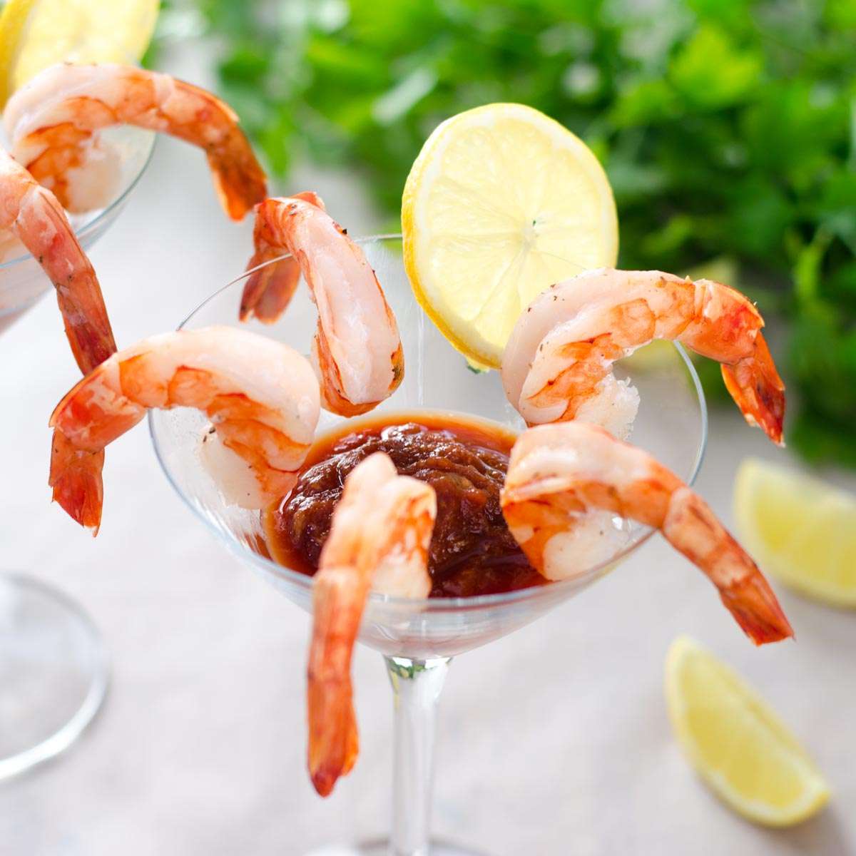 Shrimp cocktail in a glass with lemon wheel and cocktail sauce