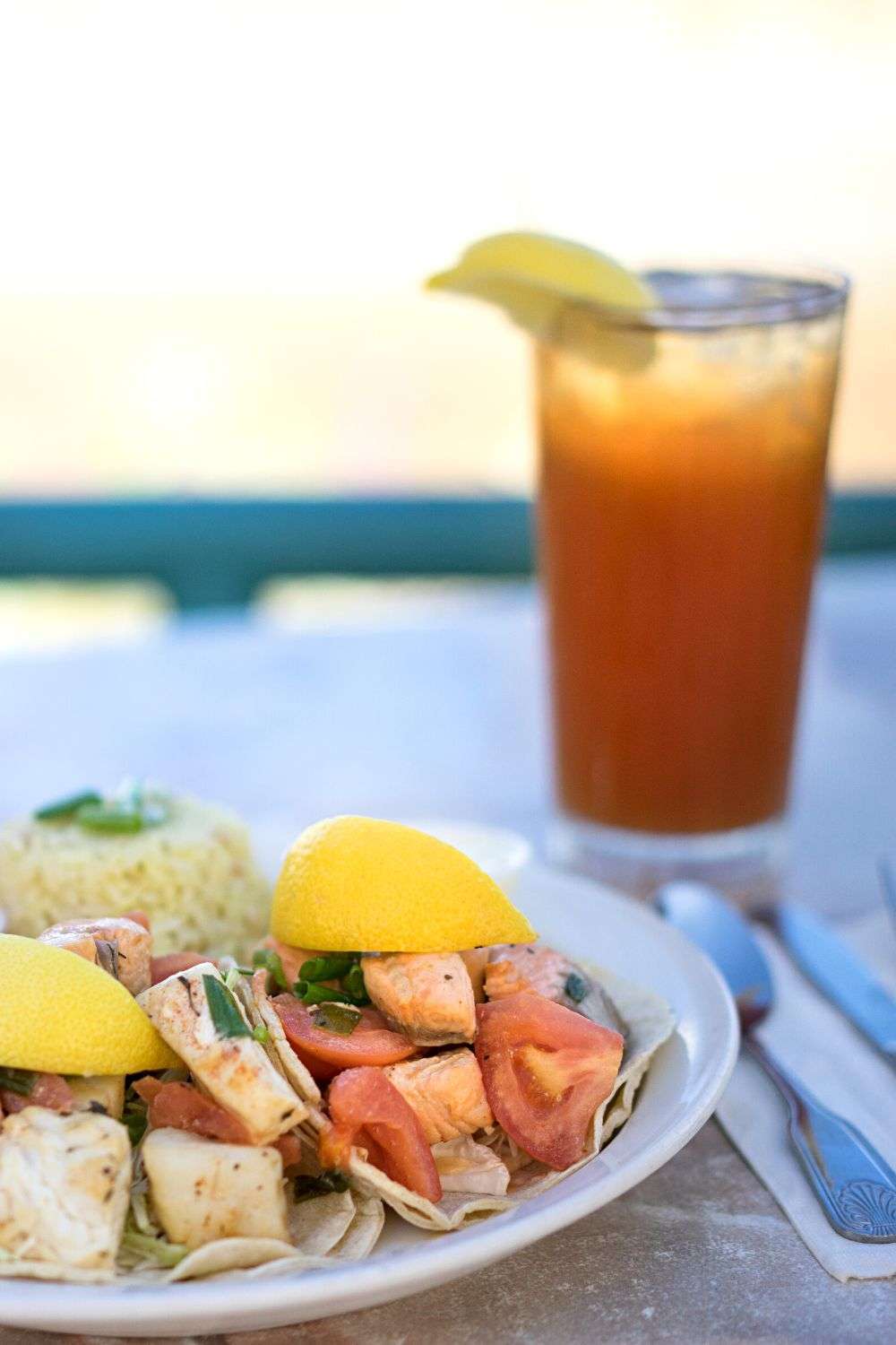 Fish tacos and iced tea on table outside