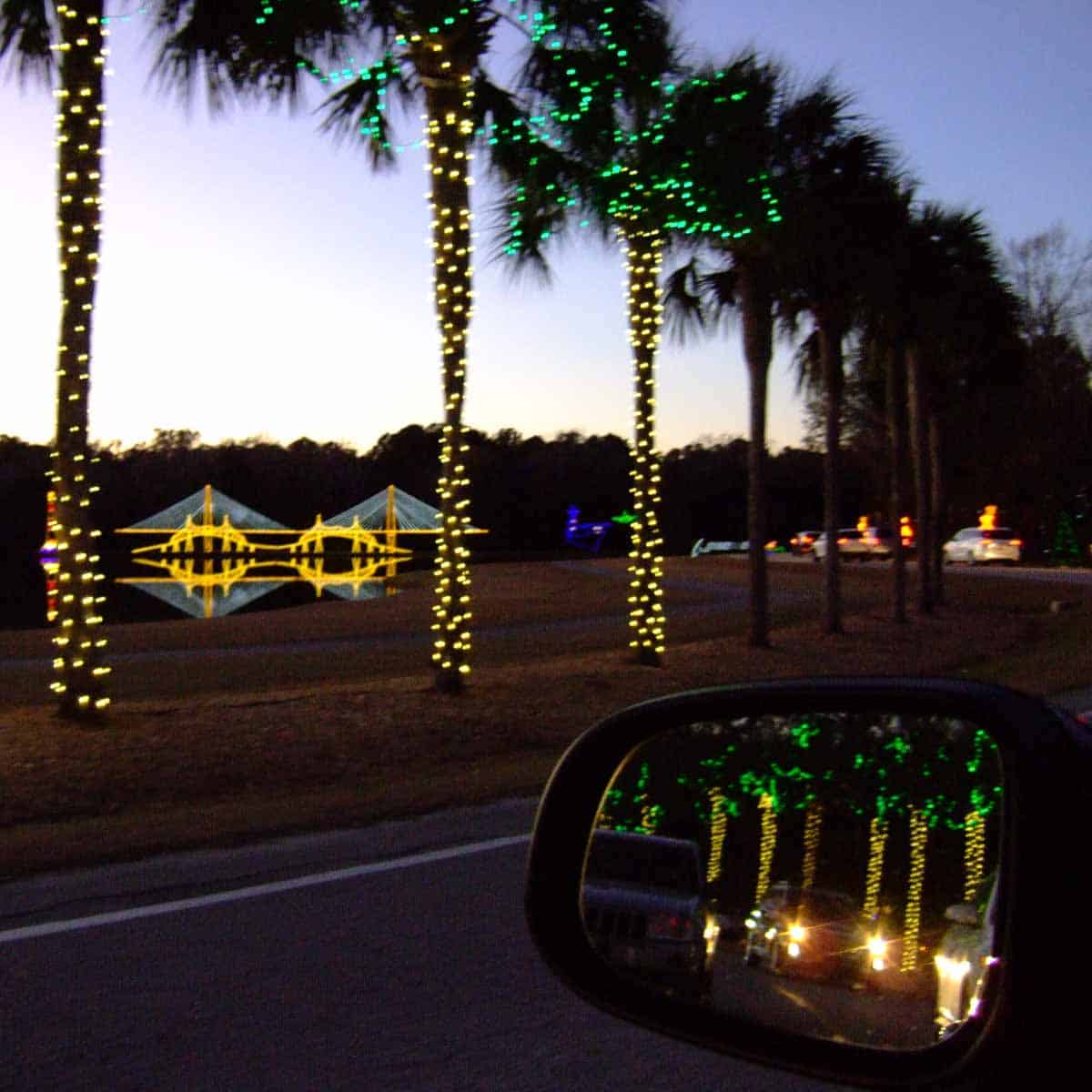 Holiday Festival of Lights drive reflected in car mirror