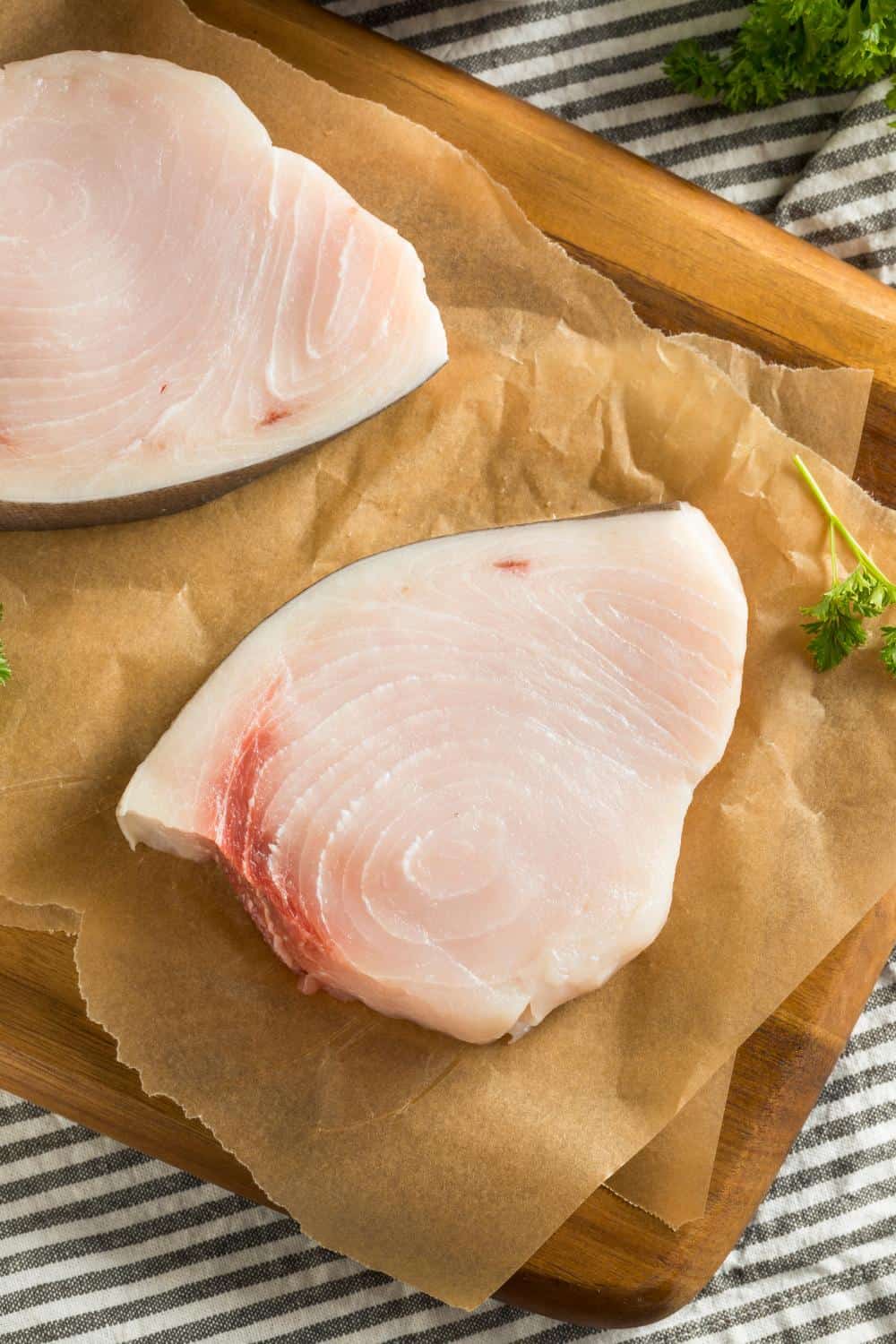 Uncooked swordfish steak on brown paper