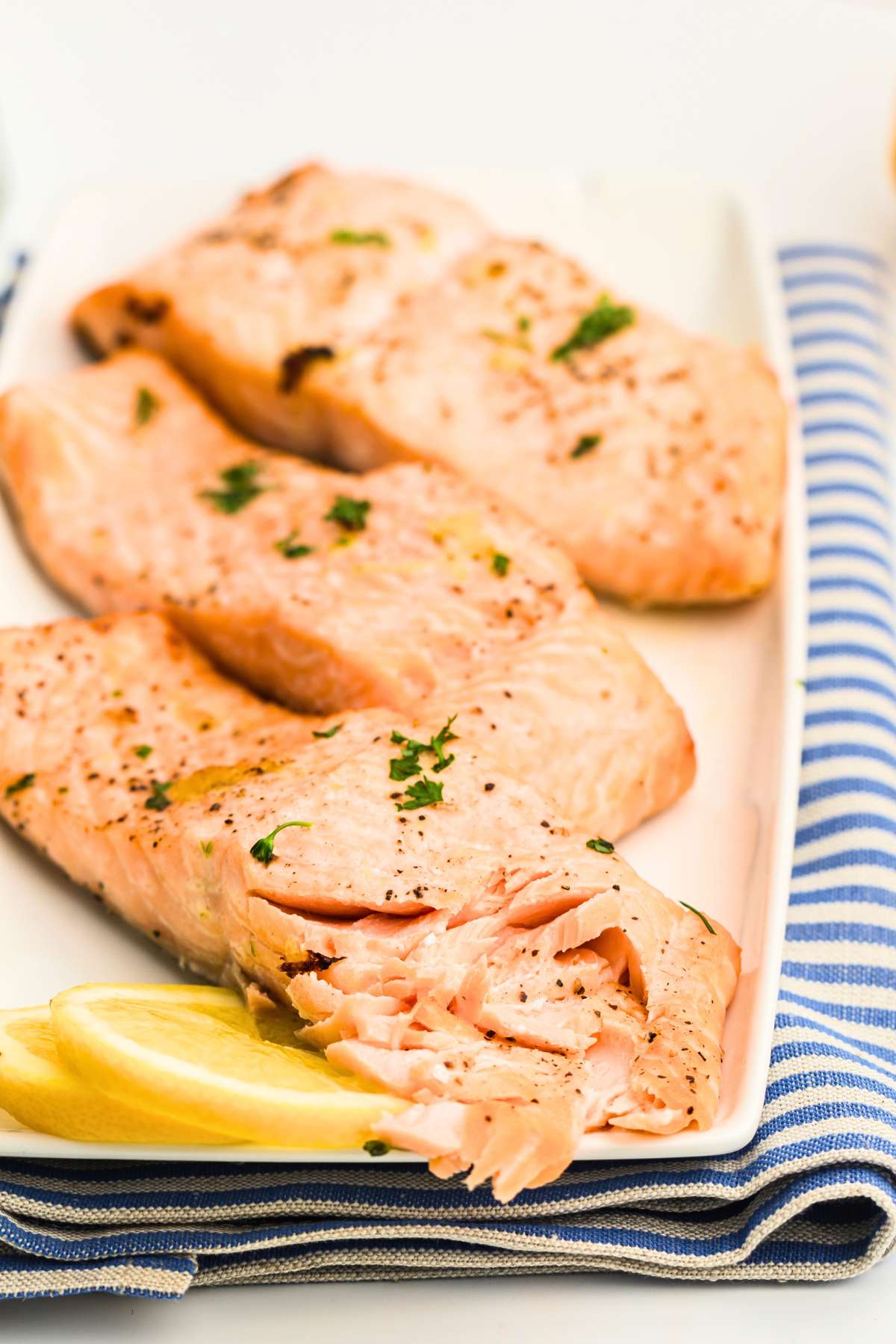 Flaked salmon filets with lemon on plate.