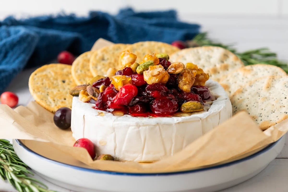 Baked cranberry brie with nuts and crackers.