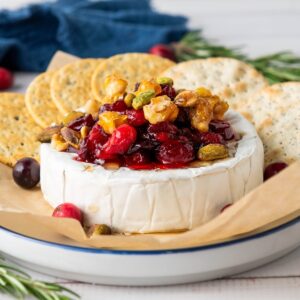 Baked cranberry brie with nuts and crackers.