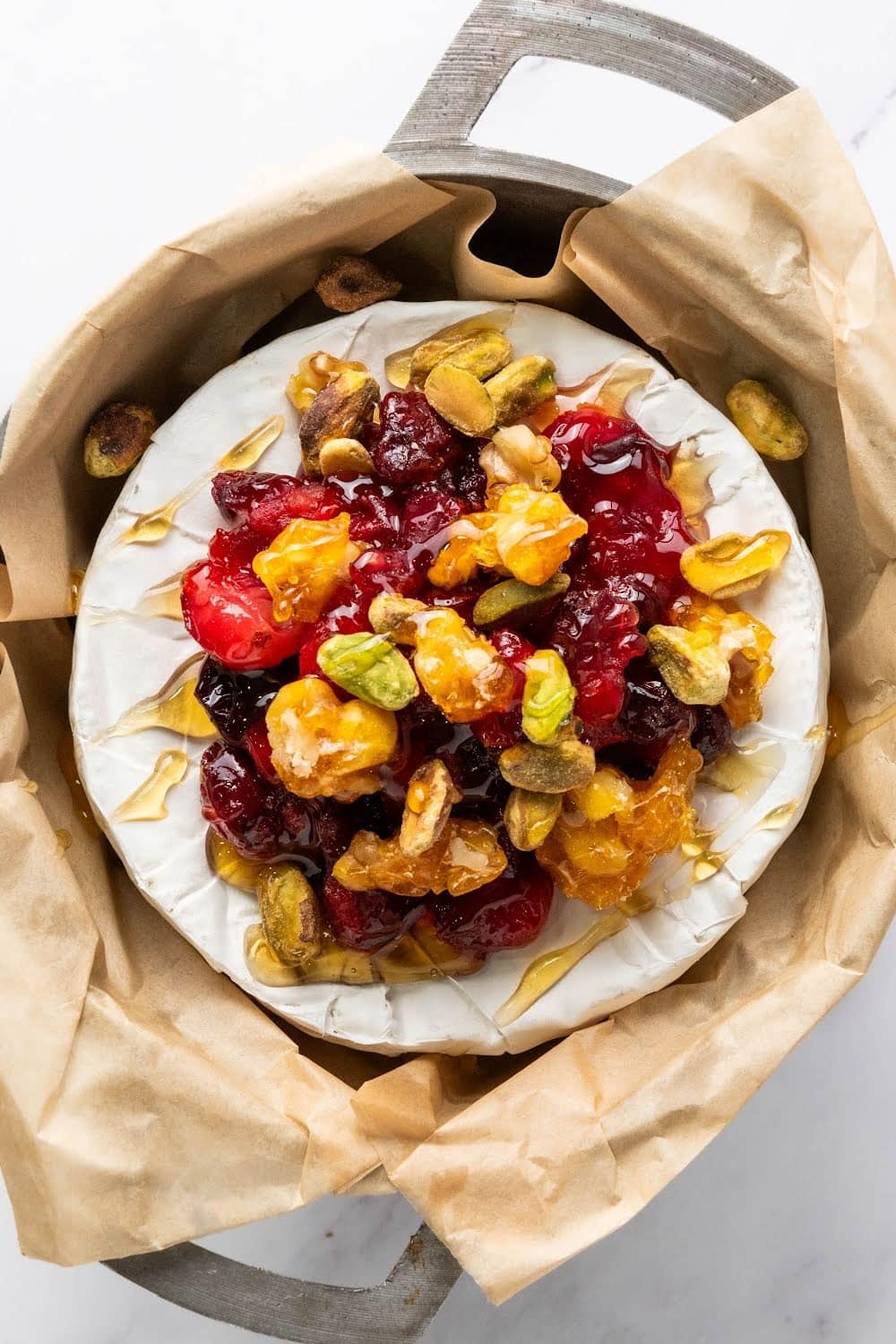 Baked brie with cranberries, walnuts, pistachios and honey.