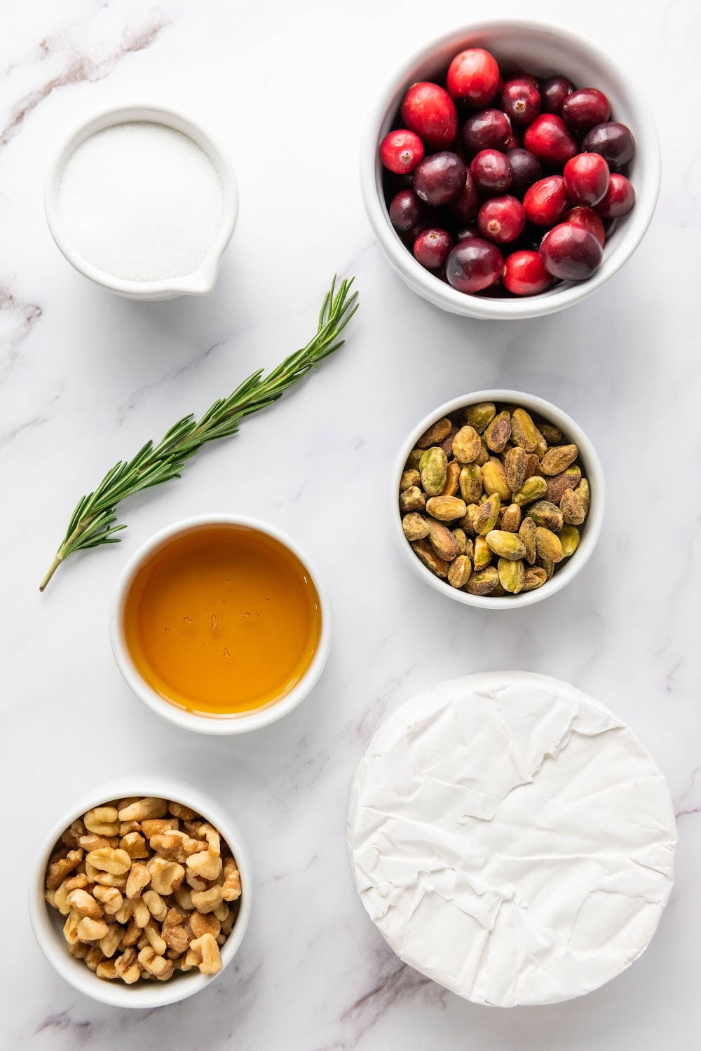 Sugar, cranberries, rosemary, pistachios, honey, walnuts, brie wheel.