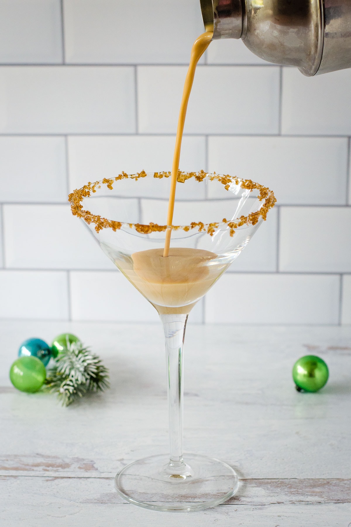 Pouring eggnog espresso drink into cocktail glass