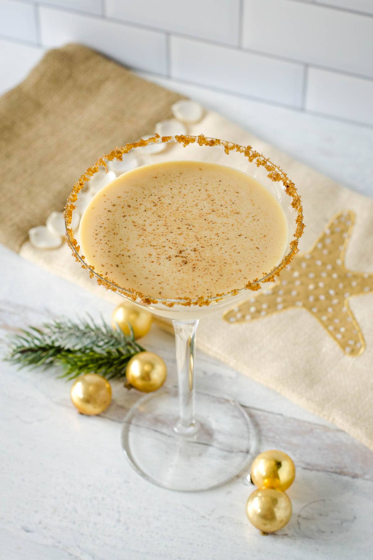 Eggnog martini with mini gold ball ornaments and star stocking.