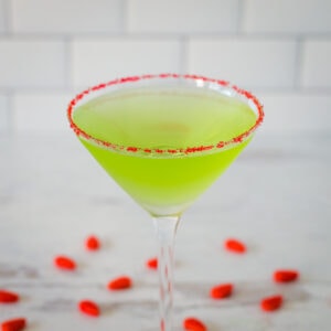 Grinch martini with red sugar rim and red candies.