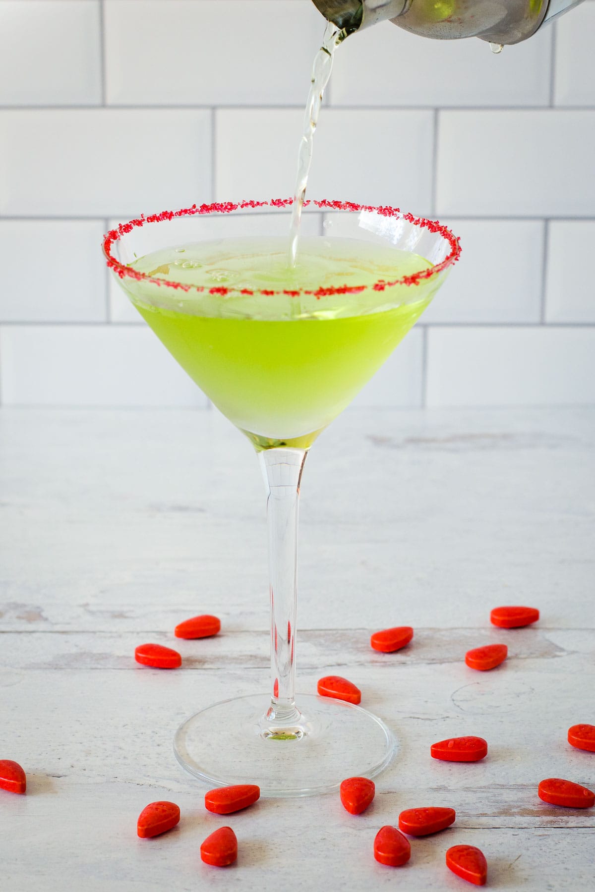 Grinch martini with red sugar rim and red candies.