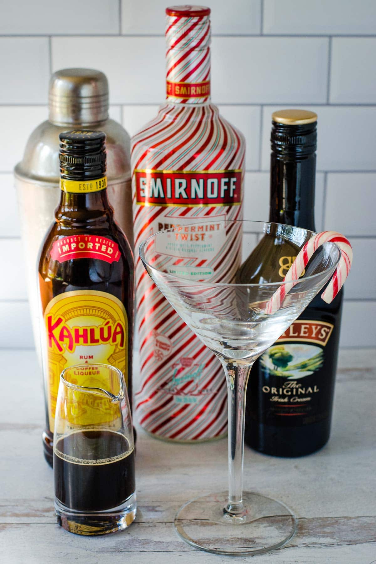 Coffee, Kahlua, cocktail shaker, vodka, Irish cream liqueur and glass with candy cane.