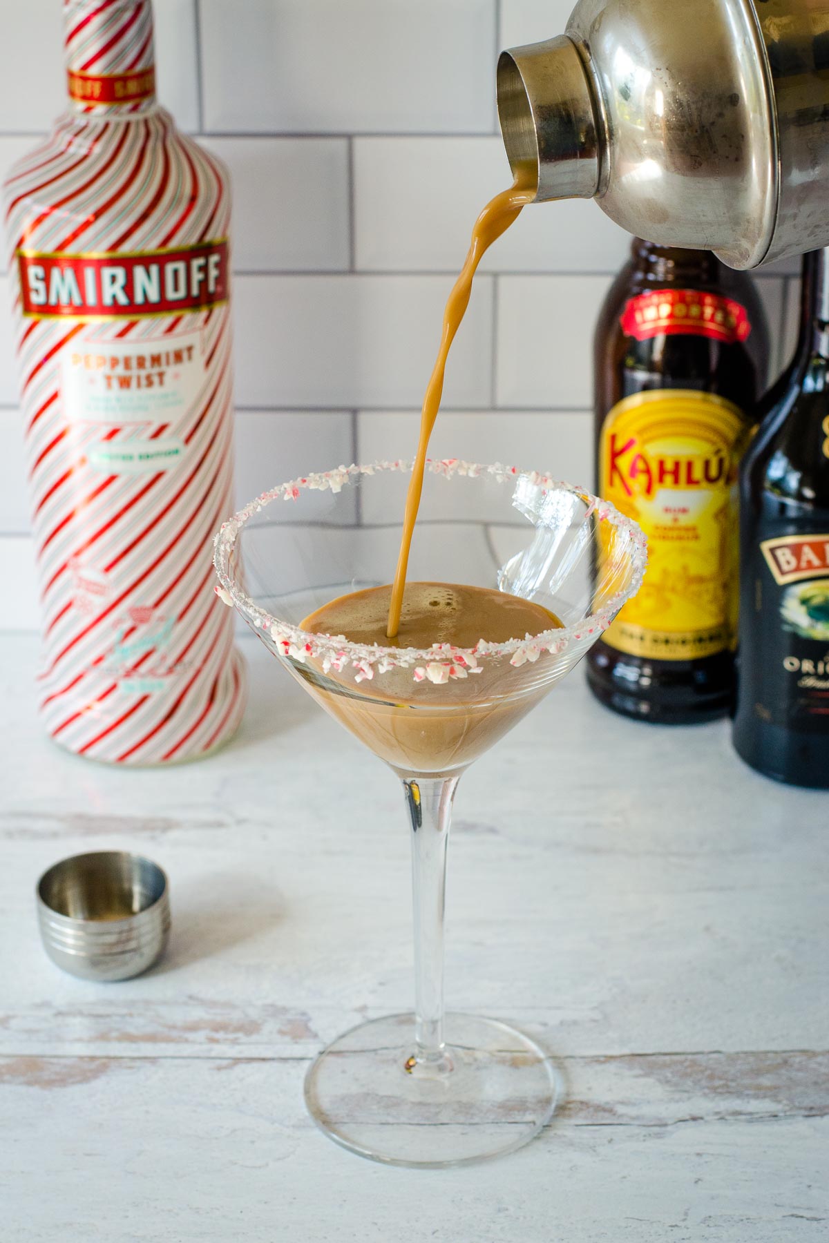 Pouring drink into cocktail glass from shaker.