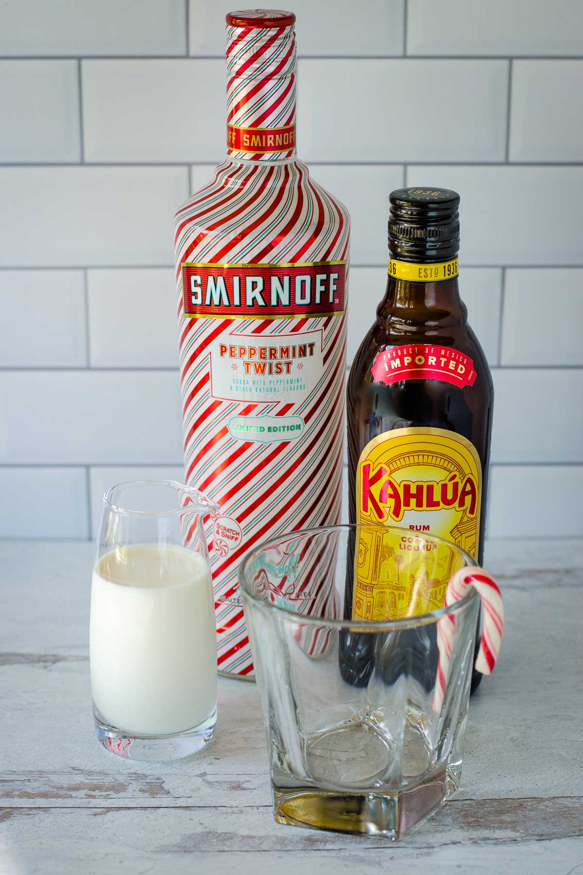 Cream, peppermint vodka, kahlua and short glass with candy cane.