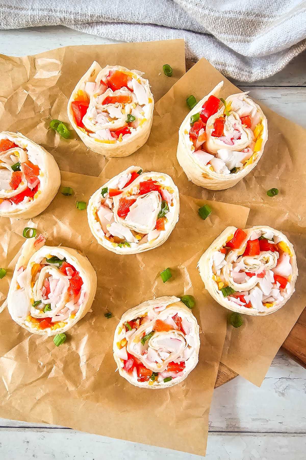 Crab tortilla pinwheels on parchment paper.