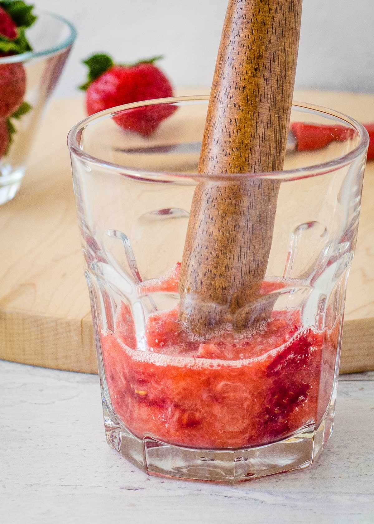 Muddling strawberries in glass