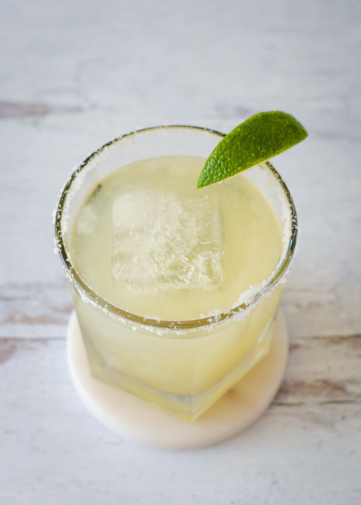 Classic margarita with lime wedge on rim of glass.