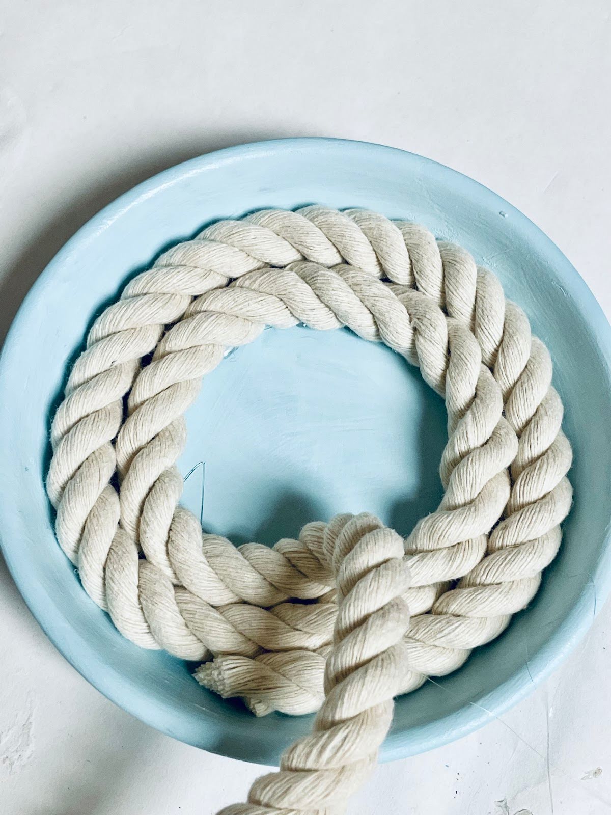 Light blue coaster with two rows of rope glued on.