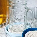 DIY coasters painted in shades of blue, with a mason jar mug on one coaster.
