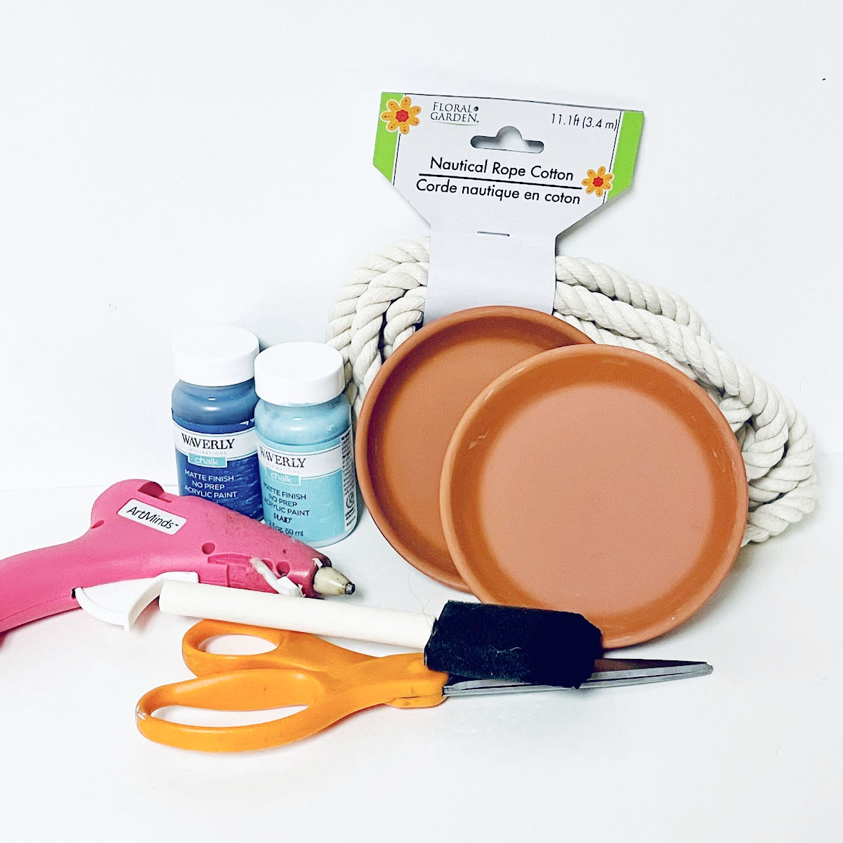 Coaster craft project materials including terra cotta saucers, blue paint, rope, glue gun, sponge paint brush, and scissors. 