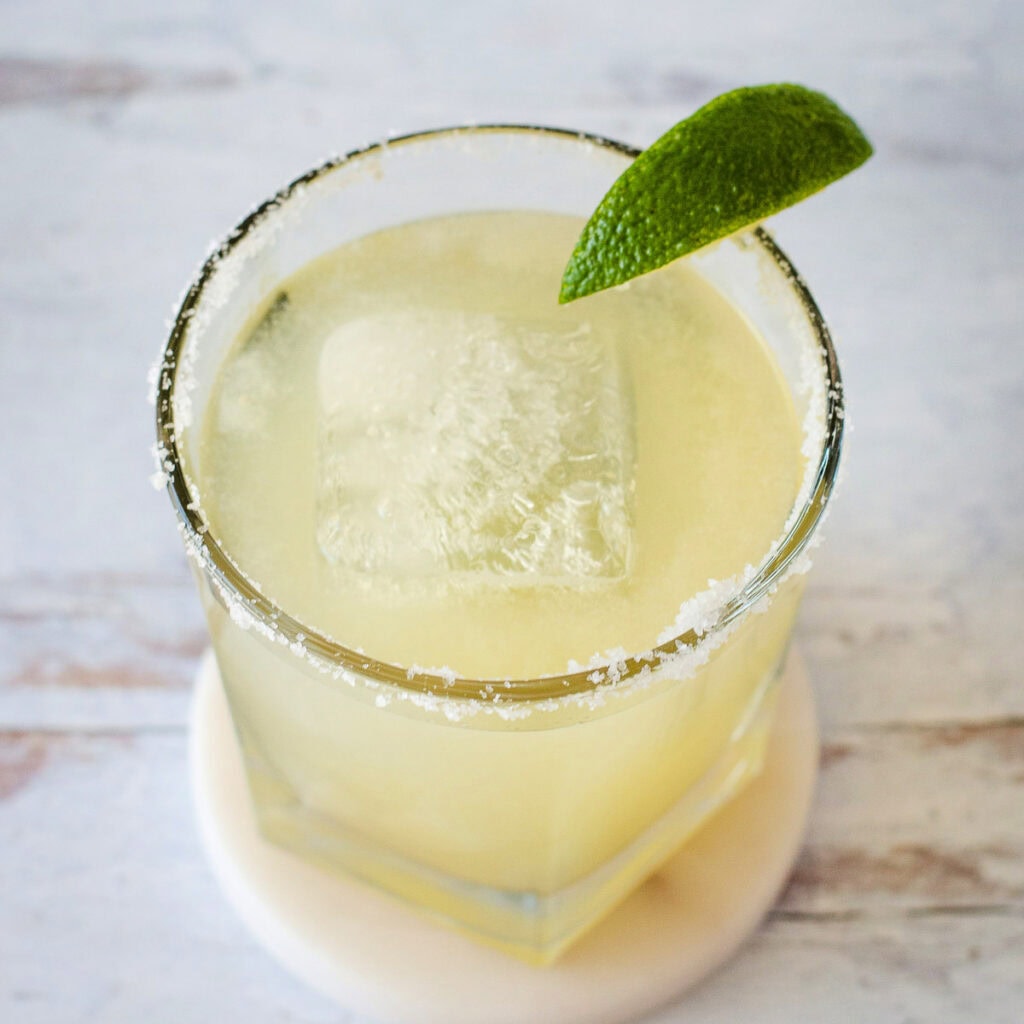 Classic margarita with lime wedge on rim of glass.