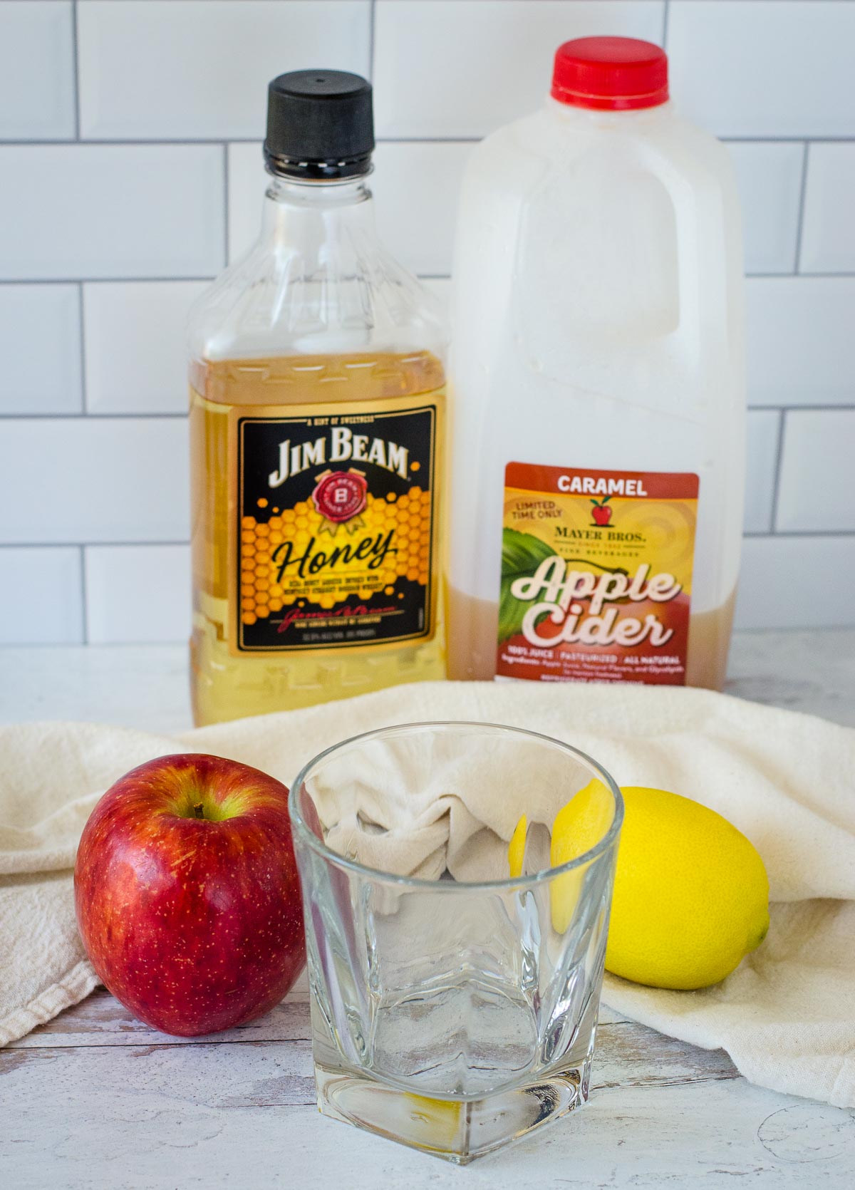 Jim Beam Honey, apple cider, apple, rocks glass and lemon.