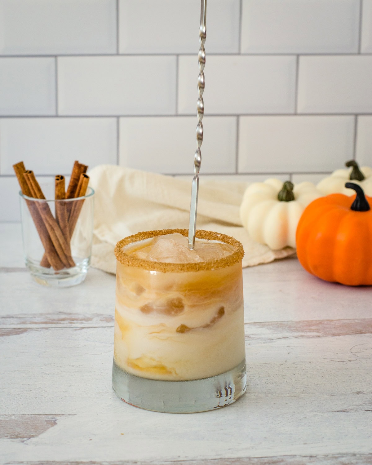 Stirring drink in glass with long spoon.