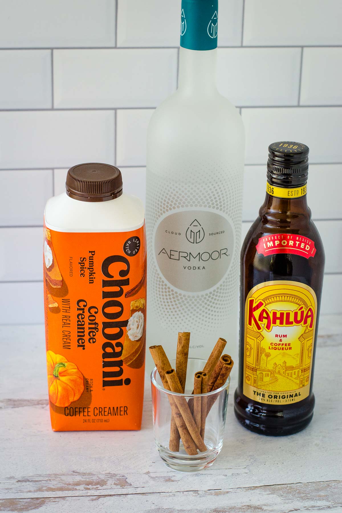 Chobani Pumpkin Spice Coffee Creamer, Aermoor Vodka, Kahlua and a glass of cinnamon sticks.