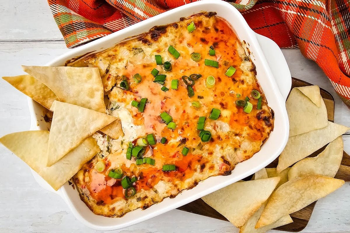 Crab rangoon dip with wonton chips in baking dish.