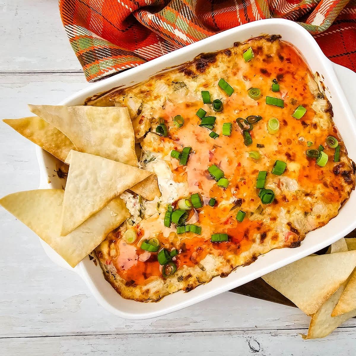 Crab rangoon dip with wonton chips in baking dish.