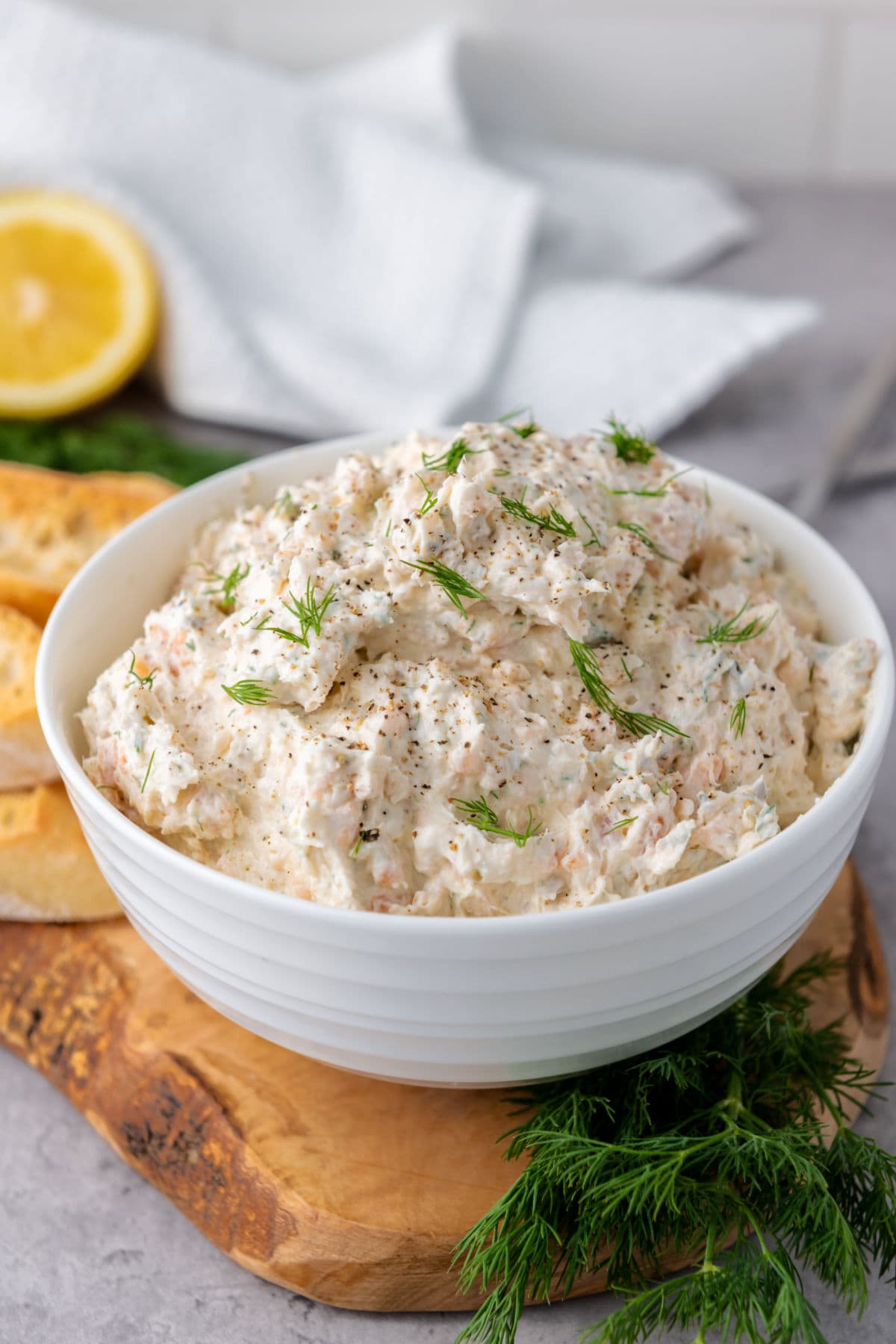Smoked salmon cream cheese dip with dill in a white bowl.